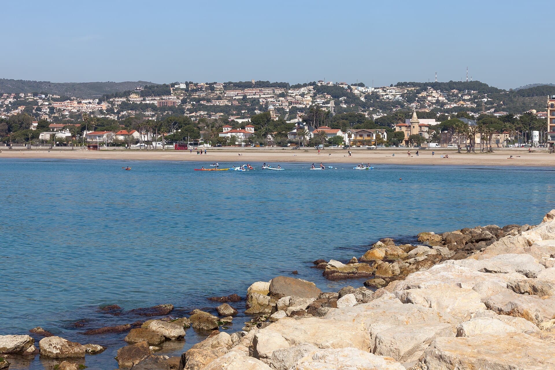 The bay at Coma-ruga with calm turquoise water and the town behind the beach